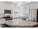 Bright kitchen featuring granite countertops, stainless steel appliances, and white cabinetry at 4028 N Rome St, Aurora, CO 80019