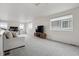 Spacious living room with neutral tones, bright windows, and modern entertainment center on soft carpeting at 4028 N Rome St, Aurora, CO 80019