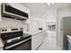 Bright kitchen boasts stainless appliances, white cabinetry, and a center island open to the living area at 13095 W Cedar Dr # 302, Lakewood, CO 80228