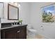 Cozy bathroom with dark vanity, granite countertop, toilet, mirror and natural light from the window at 7226 Dove Ct, Parker, CO 80134