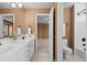 Bathroom with double sinks, an ensuite toilet, a tub, and a window with outdoor views at 7226 Dove Ct, Parker, CO 80134