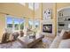 Elegant living room featuring a cozy fireplace, comfortable seating, large windows, and natural light at 7226 Dove Ct, Parker, CO 80134