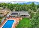 Aerial view of backyard with brick patio, in-ground pool, and well-manicured lawn with mature trees at 12176 W Ohio Pl, Lakewood, CO 80228