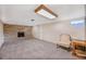 Open basement area featuring stone fireplace, plush carpeting, natural light, and a comfortable chair at 12176 W Ohio Pl, Lakewood, CO 80228