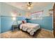 Charming bedroom featuring blue walls, a decorative accent flower, and a plush bed with colorful accents at 12176 W Ohio Pl, Lakewood, CO 80228
