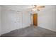 Neutral bedroom offers carpet, closet, ceiling fan, and a warm toned wooden door at 12176 W Ohio Pl, Lakewood, CO 80228