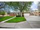 Charming brick home with a well-manicured lawn and mature trees providing shade and curb appeal at 12176 W Ohio Pl, Lakewood, CO 80228