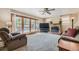 Cozy living room with a fireplace, plush carpeting, and sliding doors leading to the pool at 12176 W Ohio Pl, Lakewood, CO 80228