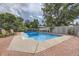 In-ground pool with brick and concrete deck surrounded by landscaped backyard and privacy fence at 12176 W Ohio Pl, Lakewood, CO 80228
