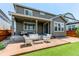 Rear elevation of the home showcasing the covered patio with outdoor seating and small turf yard at 14763 Pepper Pike Pl, Parker, CO 80134