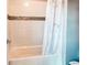 Clean bathroom with a bathtub and shower combination featuring a decorative tile accent at 14763 Pepper Pike Pl, Parker, CO 80134