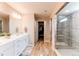 Well lit bathroom with a double vanity, walk in shower and closet access at 14763 Pepper Pike Pl, Parker, CO 80134