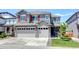 Charming two-story home featuring a three-car garage, red shutters, stone accents and a well-manicured front yard at 14763 Pepper Pike Pl, Parker, CO 80134