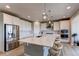 Spacious kitchen with white cabinets, a large island, stainless steel appliances, and hardwood floors, modern at 14763 Pepper Pike Pl, Parker, CO 80134