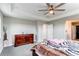 Spacious bedroom with a large dresser, a tray ceiling and modern ceiling fan with attached bath and walk in closet at 14763 Pepper Pike Pl, Parker, CO 80134