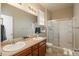 Bathroom with double sinks, large mirror and a glass-enclosed shower for a spa-like feel at 6434 N Ensenada Ct, Aurora, CO 80019