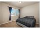 Comfortable bedroom featuring a queen-size bed, plush carpet, and a bright window with blue curtains at 6434 N Ensenada Ct, Aurora, CO 80019