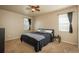 Comfortable bedroom featuring plush carpet, a ceiling fan, and natural light from two windows at 6434 N Ensenada Ct, Aurora, CO 80019