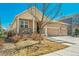 Attractive home showcasing a three-car garage, stone details, and manicured landscaping at 6434 N Ensenada Ct, Aurora, CO 80019