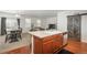 Open kitchen with island, stainless appliances, hardwood floors, pantry, dining area, and view to living room at 6434 N Ensenada Ct, Aurora, CO 80019