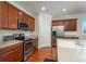 Open-concept kitchen with stainless steel appliances, center island, and ample counter space at 6434 N Ensenada Ct, Aurora, CO 80019