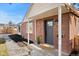 Charming brick home featuring a covered front porch and dark gray front door with a neatly landscaped yard at 3070 N Glencoe St, Denver, CO 80207
