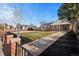 Charming brick home with beautifully landscaped front yard, mature tree, and walkway at 3070 N Glencoe St, Denver, CO 80207
