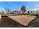 Beautifully landscaped front yard of brick house, mature tree, and new mulch at 3070 N Glencoe St, Denver, CO 80207