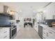 Bright kitchen with white cabinets, stainless steel appliances, and dining area with natural light at 3070 N Glencoe St, Denver, CO 80207