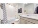 Clean, well-lit bathroom with white tiling, a gray vanity, a shower with glass door, and modern fixtures at 4642 Longs Peak St, Brighton, CO 80601