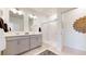 Modern bathroom with double sinks, gray cabinets, a glass-enclosed shower, and stylish decor at 4642 Longs Peak St, Brighton, CO 80601