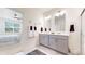 Bright bathroom featuring double vanity, neutral colors, and access to the main bedroom at 4642 Longs Peak St, Brighton, CO 80601