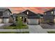 Charming home featuring a manicured lawn, a 2-car garage, and inviting front porch under a beautiful sunset sky at 4642 Longs Peak St, Brighton, CO 80601