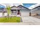 Charming home showcasing a well-kept lawn, two-car garage, and inviting front porch with a striking red front door at 4642 Longs Peak St, Brighton, CO 80601