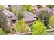 Aerial view of a charming single-story home surrounded by lush greenery and mature trees in a residential neighborhood at 1076 Rosemary St, Denver, CO 80230