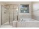 Bathtub and enclosed shower with tile surround and natural light at 1076 Rosemary St, Denver, CO 80230