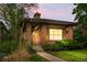 Charming single-story home with brick accents, manicured landscaping at dusk, and a welcoming front porch at 1076 Rosemary St, Denver, CO 80230