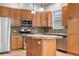 Updated kitchen with wooden cabinets, granite countertops, stainless steel appliances, and a large island at 1076 Rosemary St, Denver, CO 80230