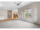 Bright living room featuring a ceiling fan, a large window, and views to the kitchen space at 1076 Rosemary St, Denver, CO 80230
