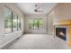 Spacious living room with multiple windows, fireplace, and plush neutral carpet for comfort at 1076 Rosemary St, Denver, CO 80230