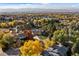 Aerial view showcasing the neighborhood in the Fall and the house with a pool, nestled among colorful foliage at 6709 Walker Ct, Niwot, CO 80503