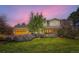 Charming two-story home with a well-manicured lawn and beautiful landscaping and a sunset in the background at 6709 Walker Ct, Niwot, CO 80503