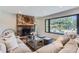 Cozy living room featuring a stone fireplace, comfortable seating, and a large window with a backyard view at 6709 Walker Ct, Niwot, CO 80503