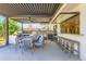 Outdoor kitchen and dining area with built-in grill, seating, and a retractable awning at 6709 Walker Ct, Niwot, CO 80503