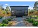 A stylish outdoor shed is surrounded by gravel, flower beds, and greenery at 6709 Walker Ct, Niwot, CO 80503