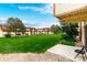 View of the backyard with a patio surrounded by a lush lawn and complex buildings at 10211 Ura Ln # 8-102, Thornton, CO 80260