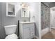 Bathroom with a toilet, sink, vanity, mirror, and shower with butterfly curtain at 10211 Ura Ln # 8-102, Thornton, CO 80260