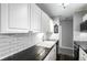 Kitchen featuring white cabinets, subway tile backsplash, black granite countertops, and stainless steel appliances at 10211 Ura Ln # 8-102, Thornton, CO 80260