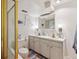 Well-lit bathroom featuring a double sink vanity, modern fixtures, and a glass-enclosed shower at 5885 W Atlantic Pl, Lakewood, CO 80227