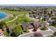Picturesque aerial view of a home in a neighborhood with mature trees, a community lake, and a nearby bridge at 12421 W Fair Dr, Littleton, CO 80127